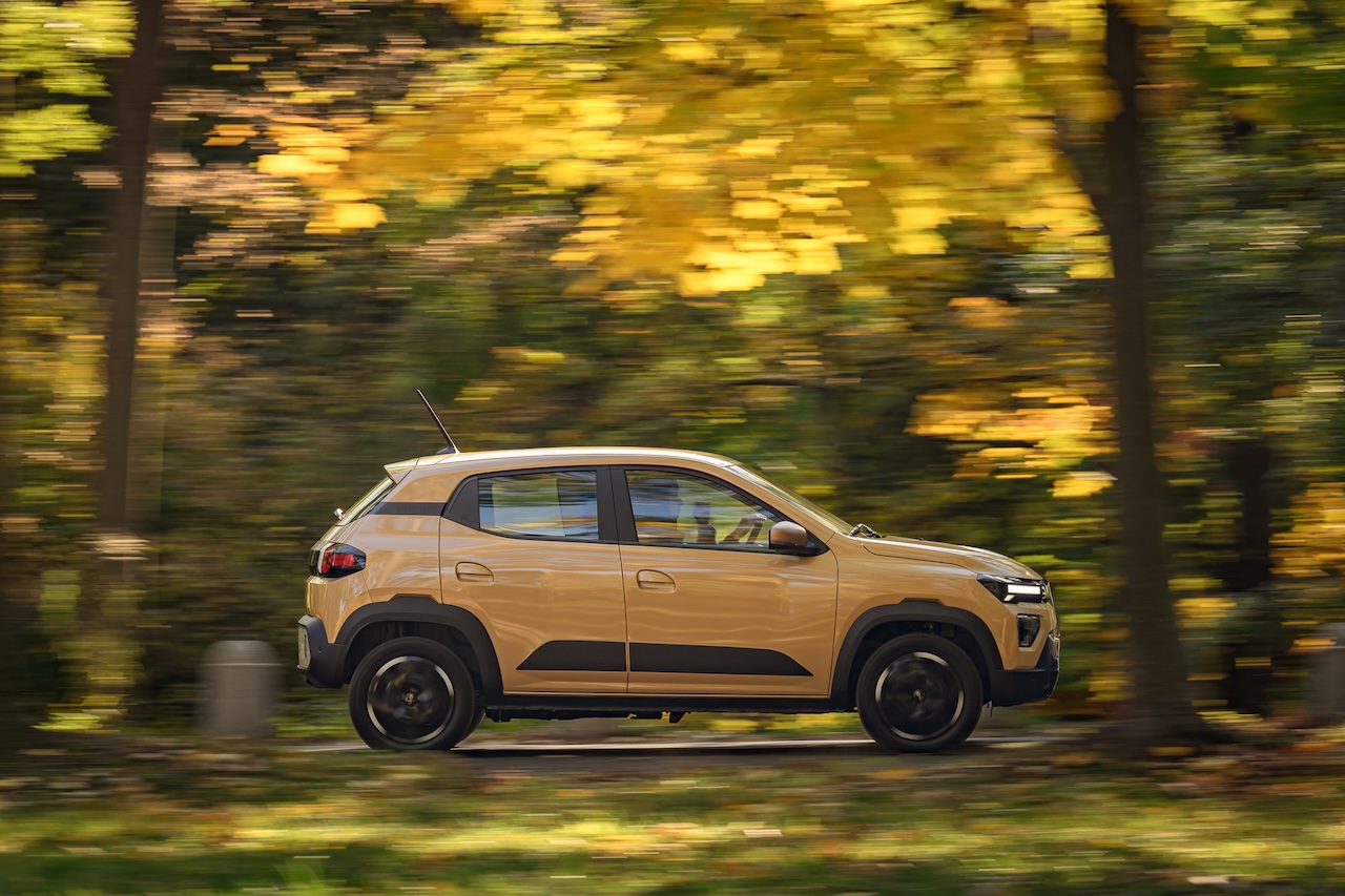 Dacia Spring w ruchu na tle jesiennego parku