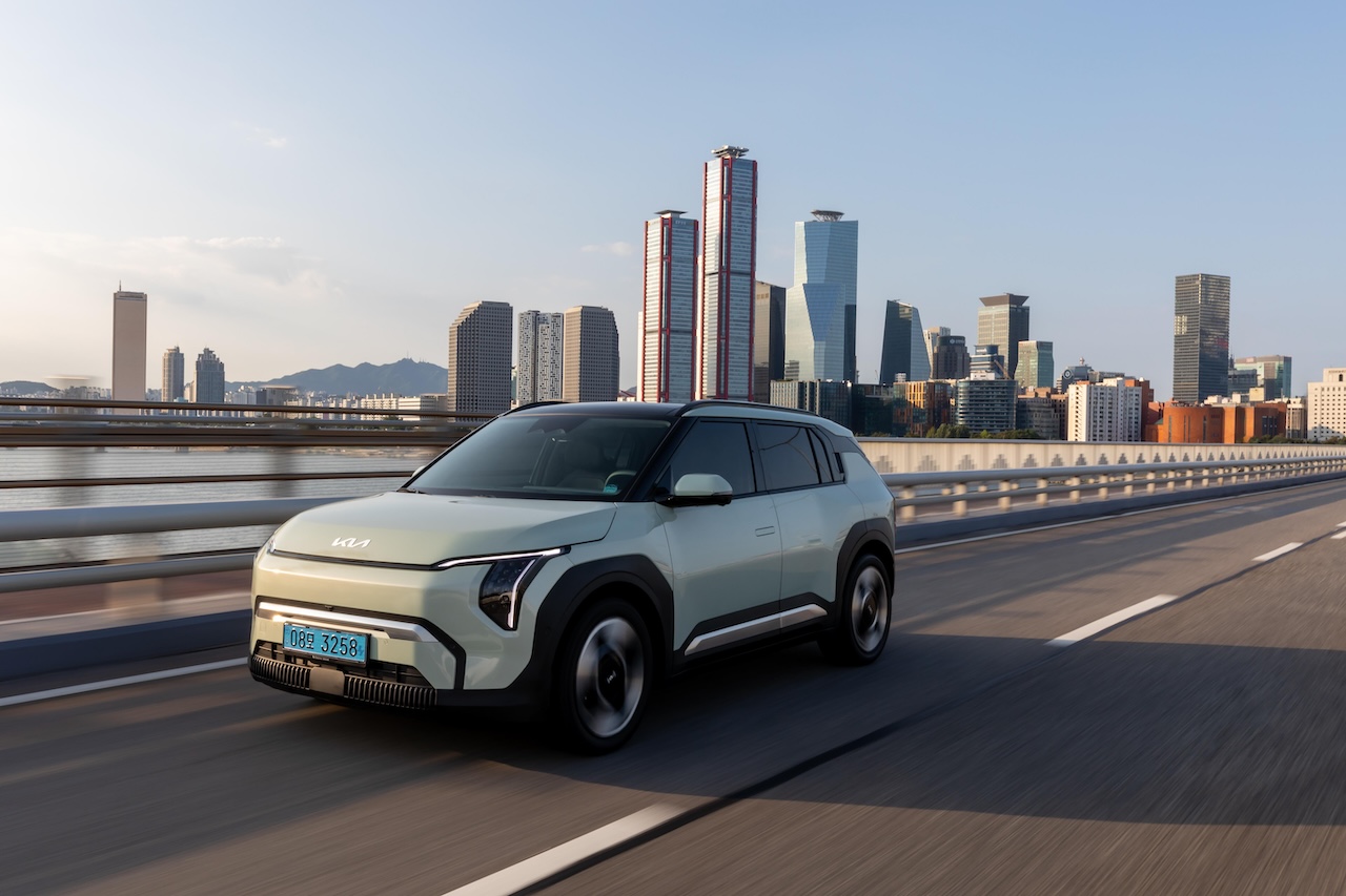 KIA EV6 na moście z panoramą miasta w tle