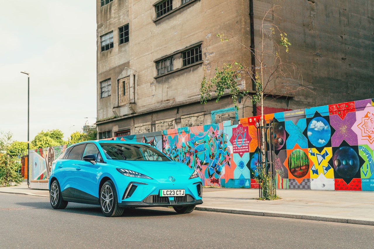 MG4 Electric w kolorze niebieskim na tle miejskiego graffiti
