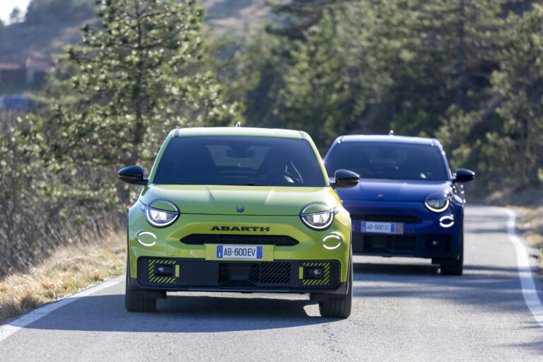 Abarth 600e zielony i niebieski podczas jazdy po górskiej drodze