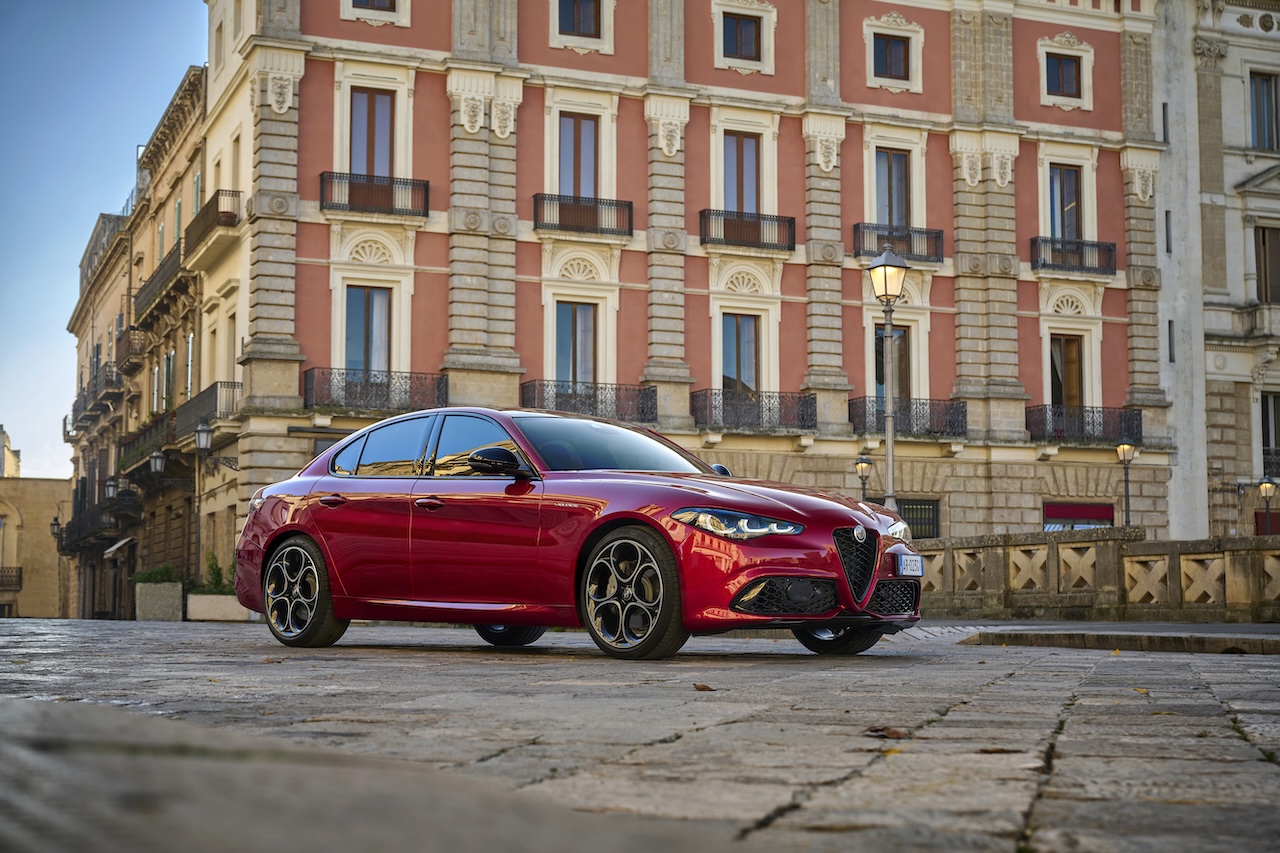 Alfa Romeo Giulia zaparkowana przed klasyczną włoską kamienicą.