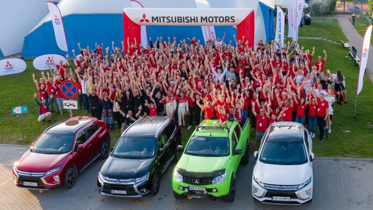 duża grupa ludzi przy samochodach Mitsubishi, ludzie przyjaźnie machają rękami - umowa Astara i Salesfore