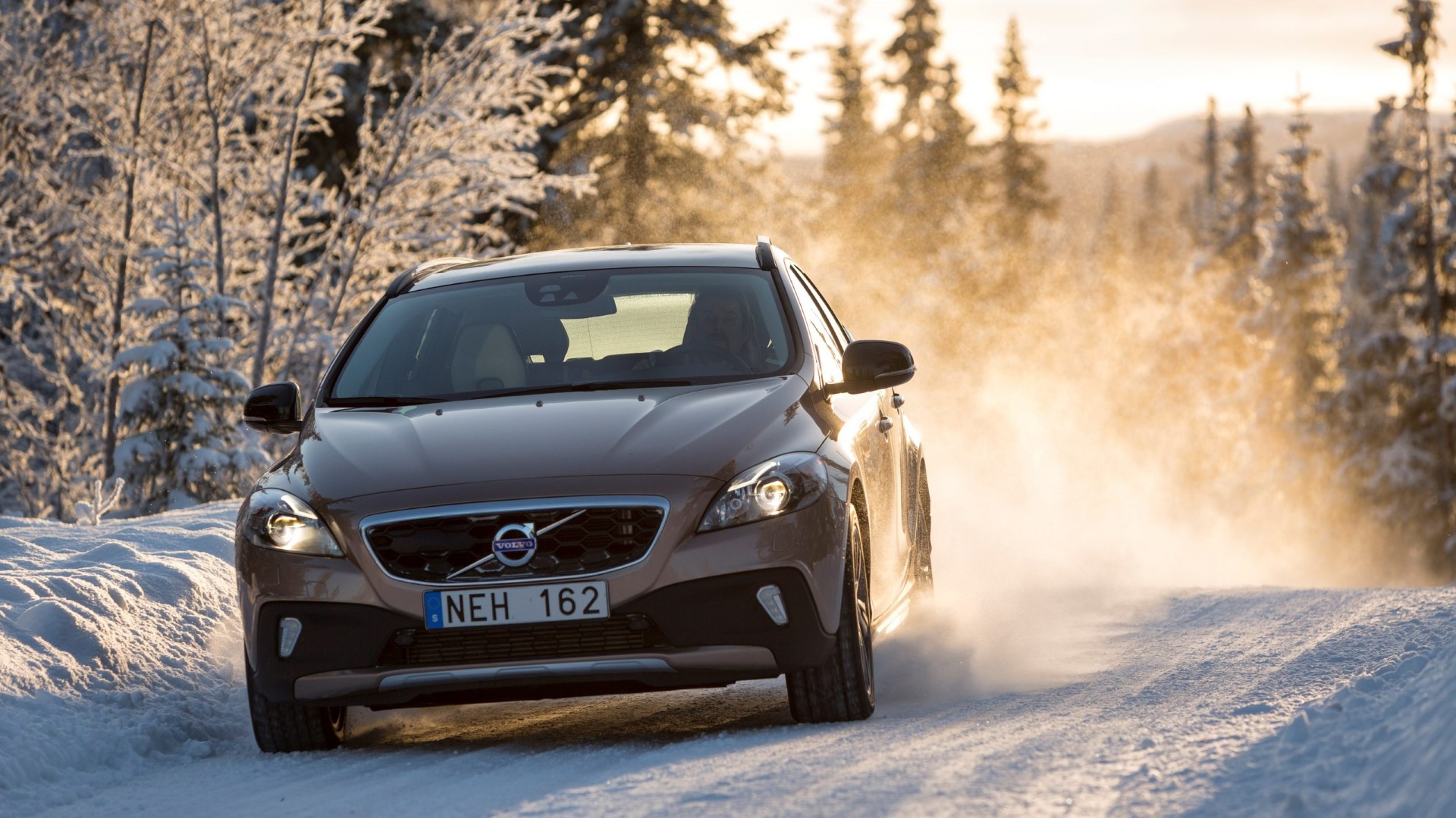 samochód zimą na tle lasu, promienie słońca i śnieżna mgła - Bezpieczne ferie z Volvo Car PGD