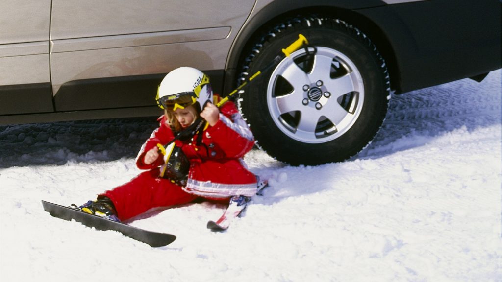 dziecko na nartach koło samochodu, samochód na śniegu, zima, Bezpieczne ferie z Volvo Car PGD; Volvo Kraków; CSR