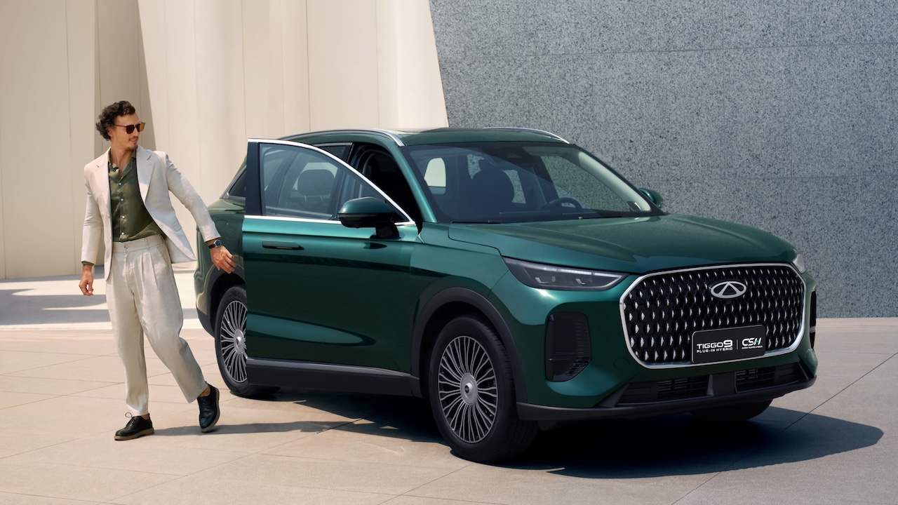 Elegancki, ciemnozielony SUV Chery Tiggo 9 zaparkowany na tle nowoczesnej, minimalistycznej architektury.