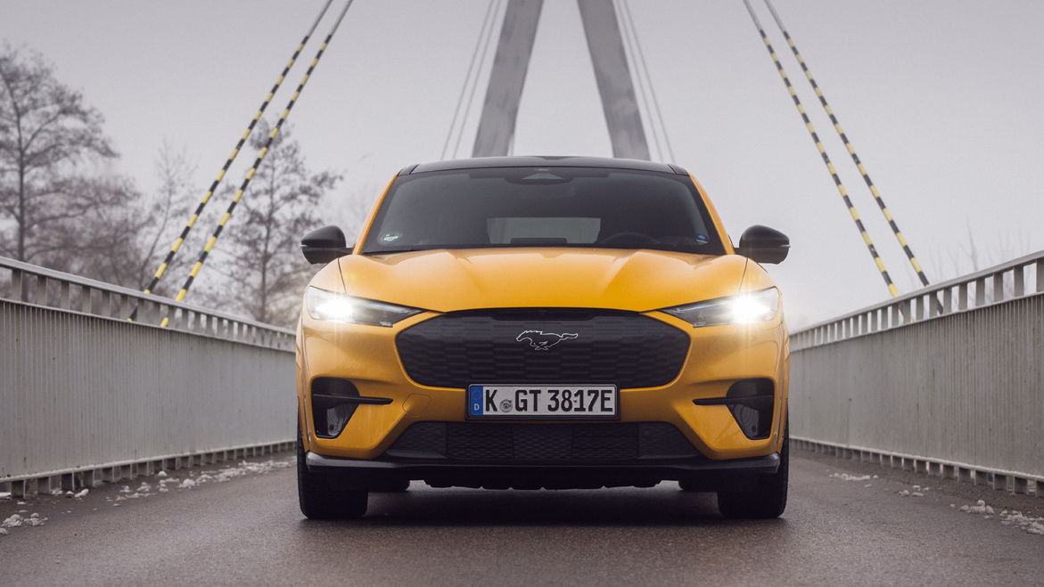 żółty elektryczny samochód sportowy z przodu, na moście, zimowe zamglenie, zasięg elektryka zimą na przykładzie: Ford Mustang Mach-E