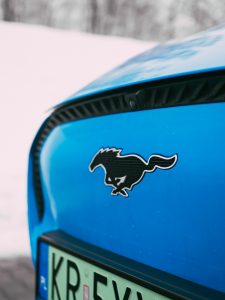 logo Mustang, niebieski lakier, przód auta Ford Mustang Mach-E wyprzedaż rocznika 2022