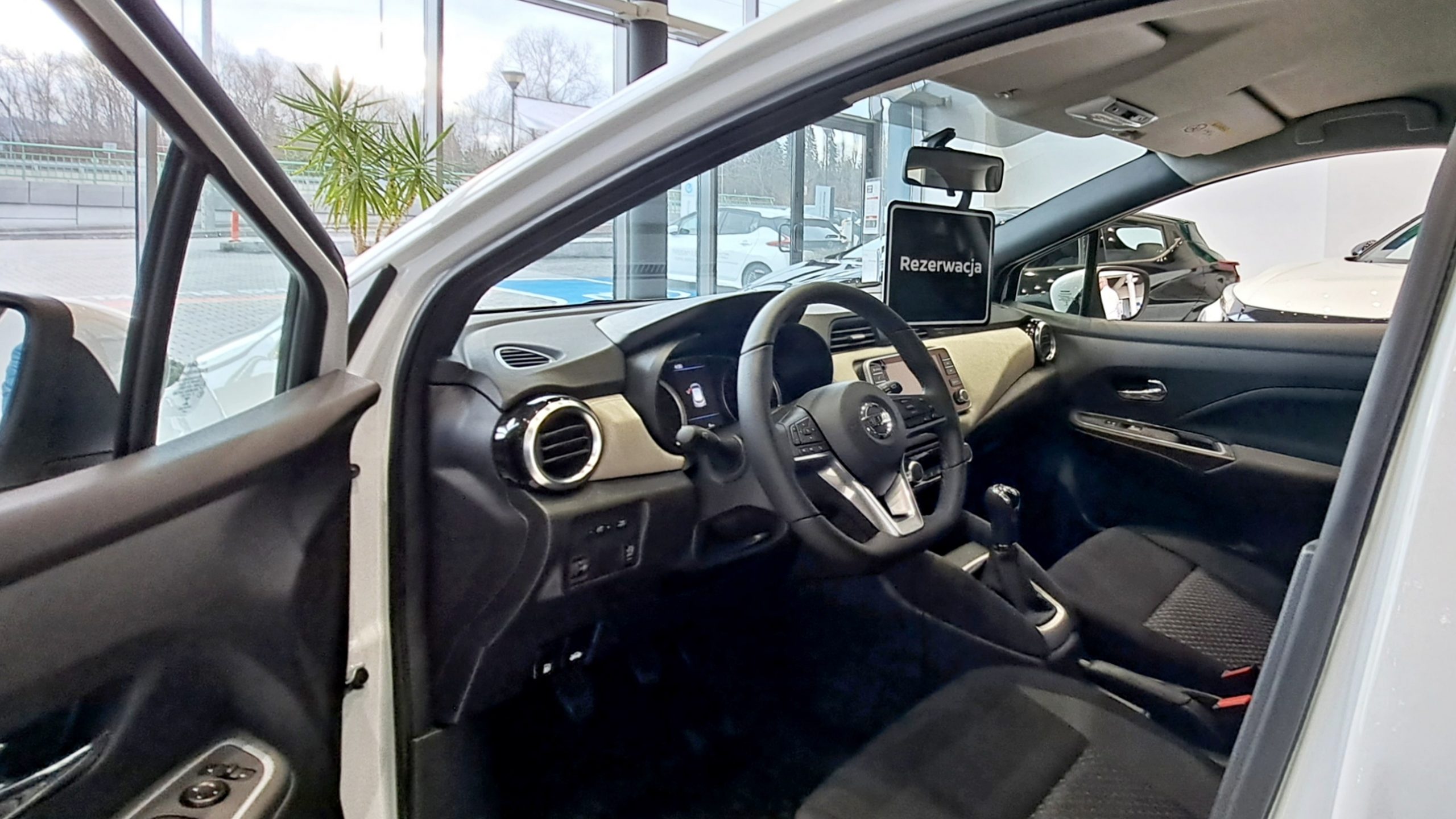 wnętrze samochodu w salonie, napis rezerwacja, Nissan Micra Acenta, wyprzedaż rocznika 2022