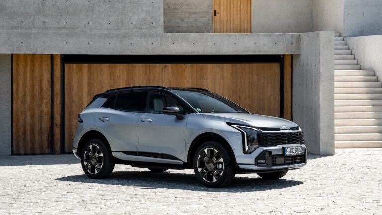 Kia Sportage z profilu na tle nowoczesnej architektury