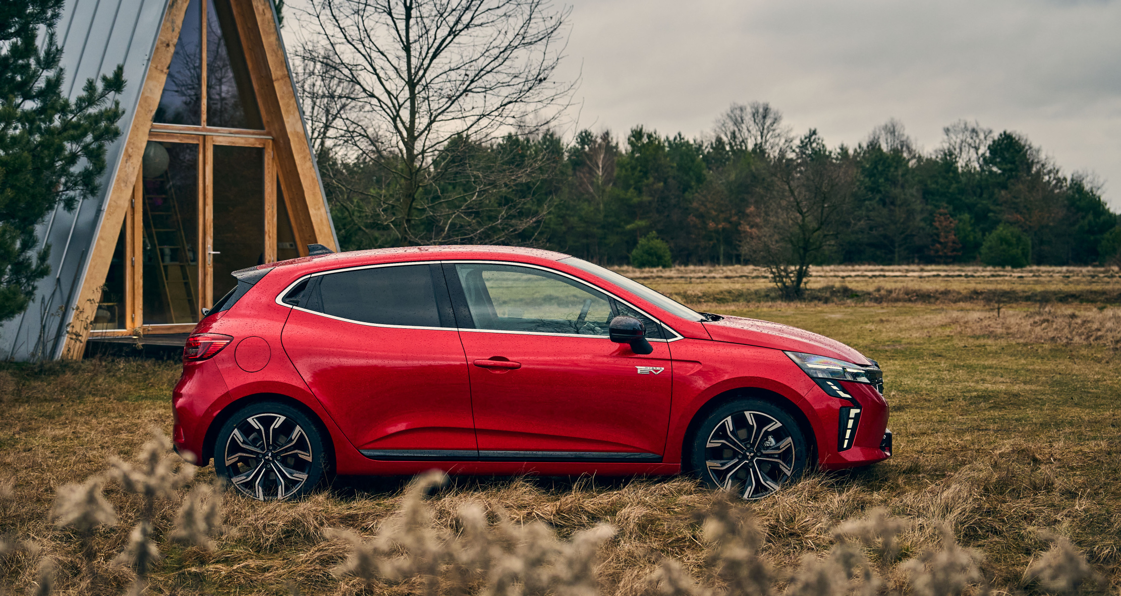 Czerwony miejski samochód typu kompakt na łące. Widok z boku. Nowy Mitsubishi Colt nagrodzony przez La Revue Automobile Références Automobiles