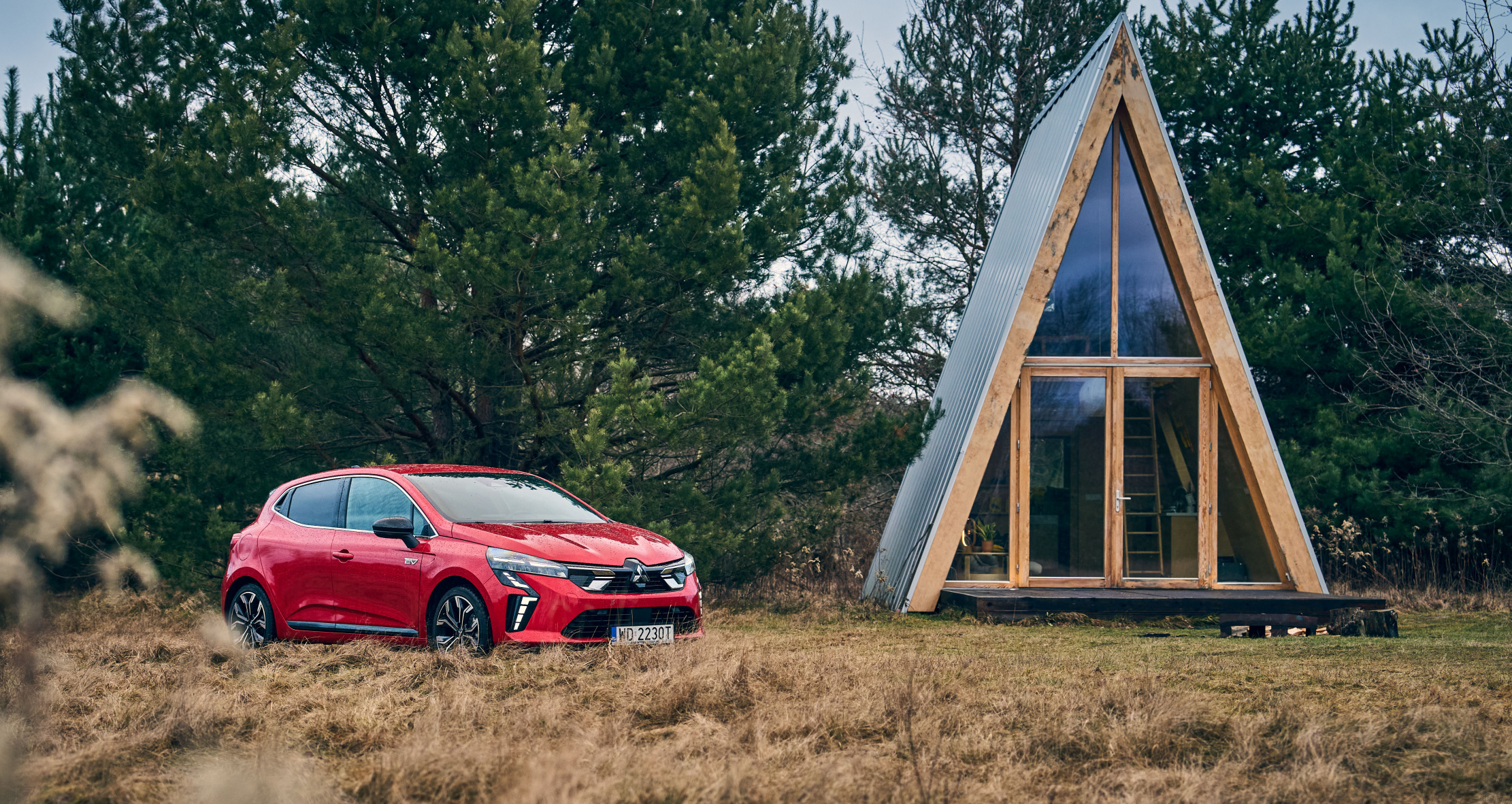 Czerwony miejski samochód typu kompakt na łące. Widok z boku/przodu. Nowy Mitsubishi Colt nagrodzony przez La Revue Automobile Références Automobiles
