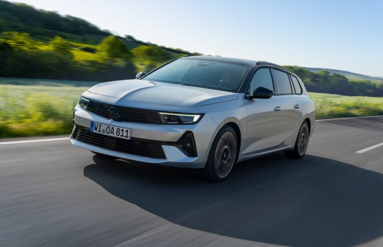 Srebrny Opel Astra Sports Tourer Hybrid w trasie, imponujący zasięg 1200 km.