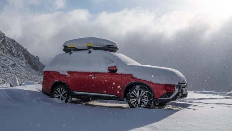 Zaśnieżony samochód typu SUV z bagażnikiem dachowym. Na śniegu w górach. Jak przygotować auto do zimy. Przedzimowa check lista Mitsubishi