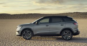 pustynia piaszczysto-kamienista i srebrne auto typu SUV - hybrydowy Renault Austral z boku