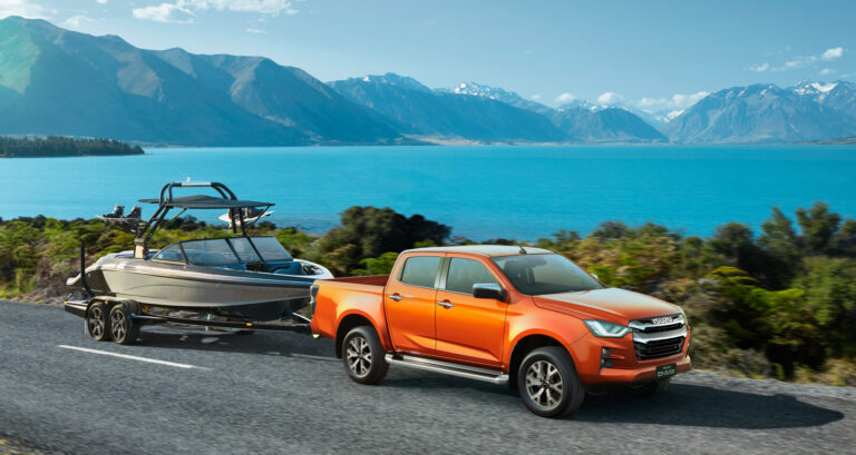 Stylowy pickup Isuzu D-Max III MY 2023 z przyczepą podłodziową, ciągnie łódź motorową