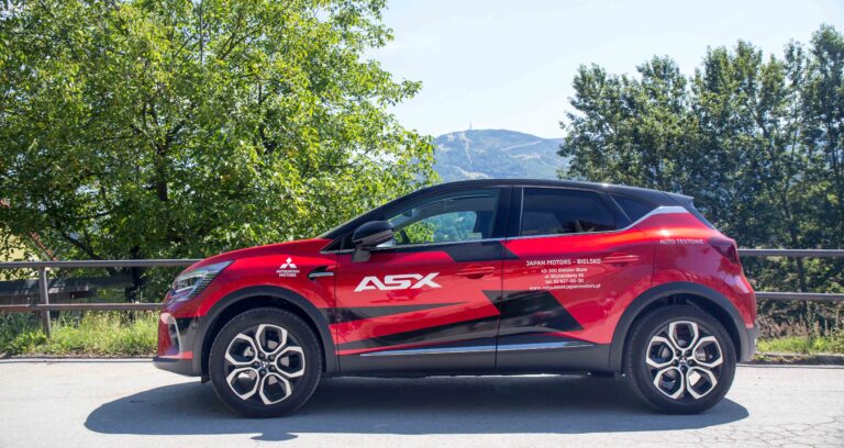 dwukolorowy czerwony i czarny miejski crossover klasy B na tle gór. W tle Skrzyczne z wieżą radiowo-telewizyjną. test Mitsubishi ASX 140 KM z manualną skrzynią biegów