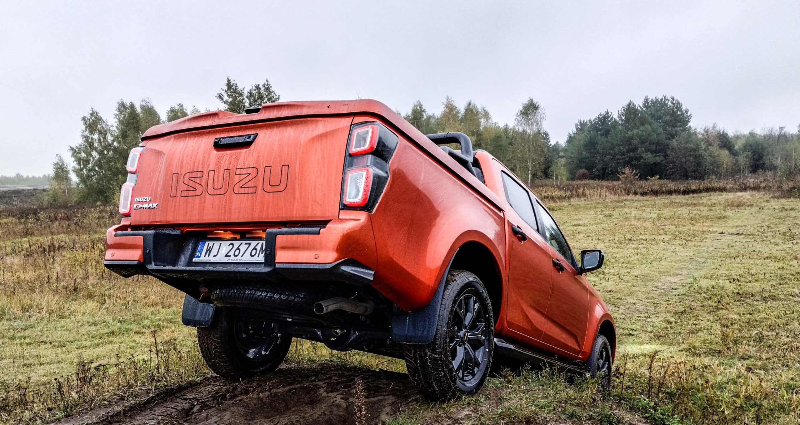 pickup Isuzu D-Max Double Cab (z podwójną kabiną) z tyłu/boku w terenie. Kąt zejścia
