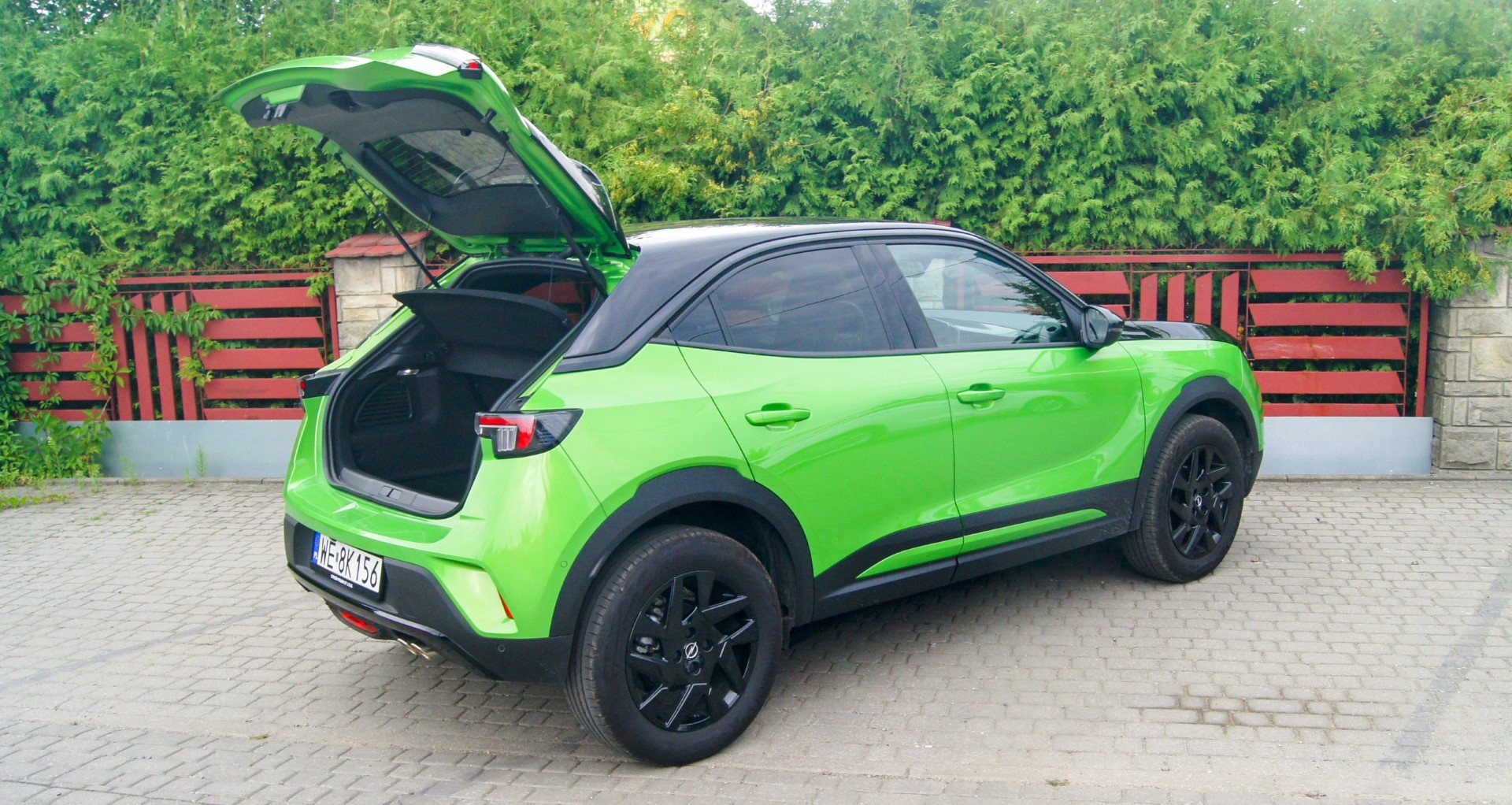zielony samochód typu crossover z otwartą uniesioną klapą bagażnika - Opel Mokka 2023 wersja GS Line